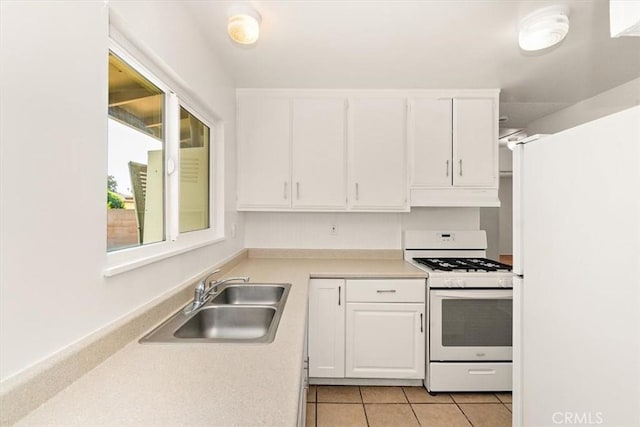 kitchen with white cabinets, light tile patterned floors, sink, and white appliances