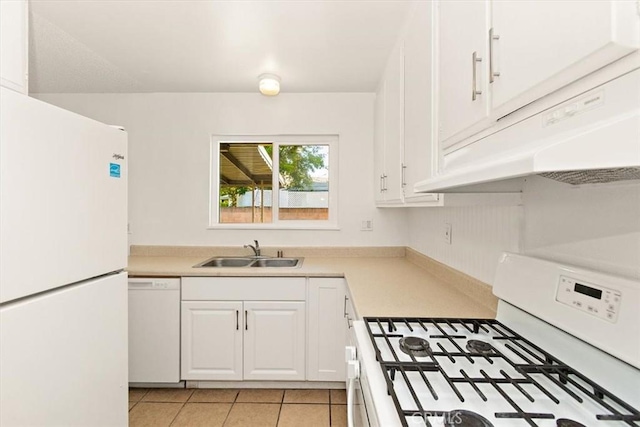 kitchen with light tile patterned floors, sink, white cabinets, and white appliances