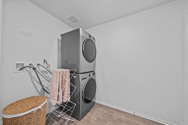 laundry room with stacked washing maching and dryer