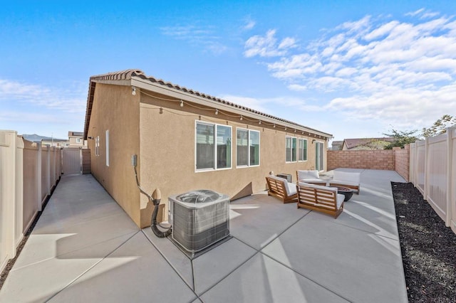 rear view of property featuring an outdoor living space, a patio area, and central AC