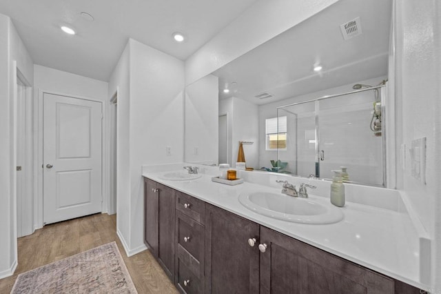 bathroom with hardwood / wood-style flooring, an enclosed shower, and vanity