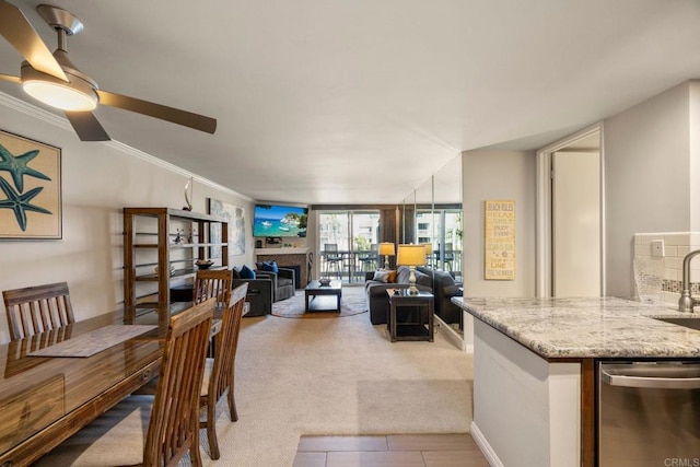 dining room featuring light carpet, ceiling fan, sink, and crown molding