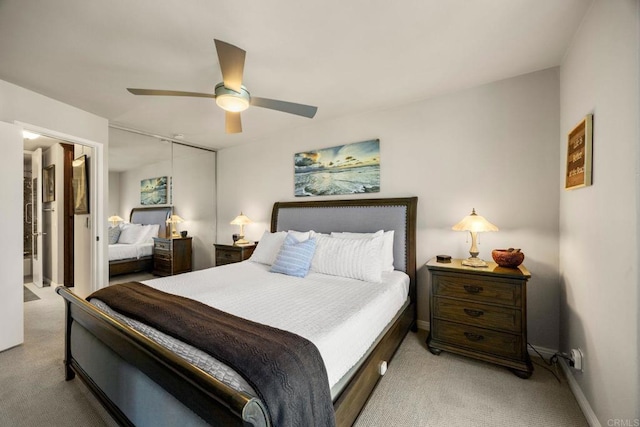 bedroom featuring ceiling fan, light carpet, a closet, and connected bathroom