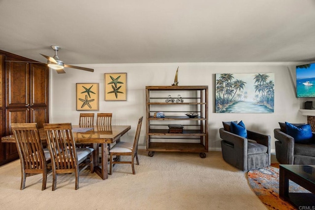 carpeted dining room featuring ceiling fan and ornamental molding