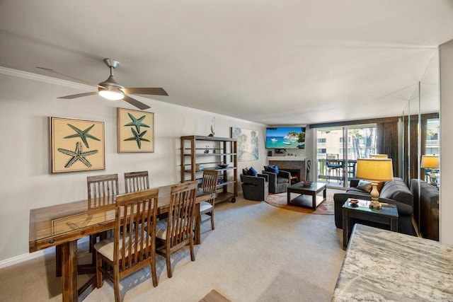 carpeted dining room with ceiling fan and crown molding