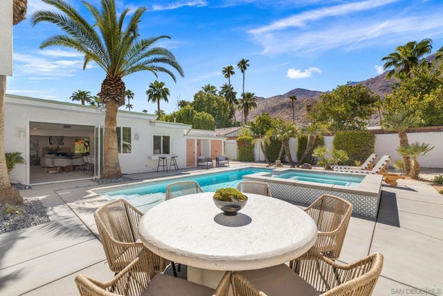 view of swimming pool with a mountain view, an in ground hot tub, and a patio