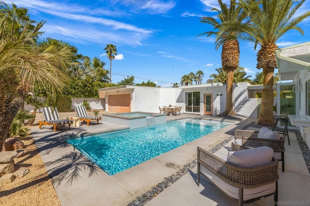 view of pool featuring a patio area and an in ground hot tub