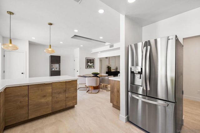 kitchen with stainless steel refrigerator with ice dispenser and pendant lighting