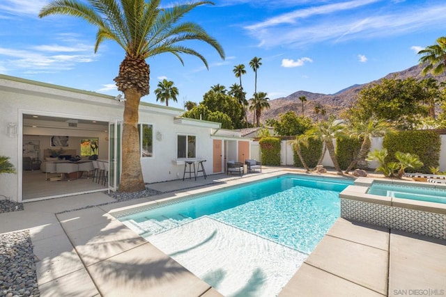 view of pool featuring a mountain view, an in ground hot tub, and a patio