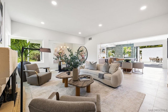 tiled living room featuring plenty of natural light and an inviting chandelier