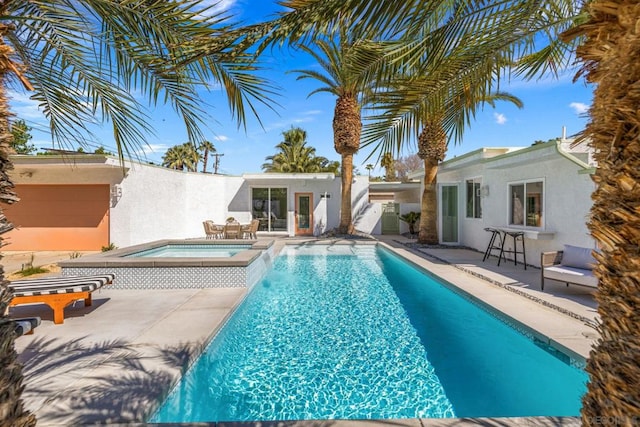 view of pool with a patio area and an in ground hot tub