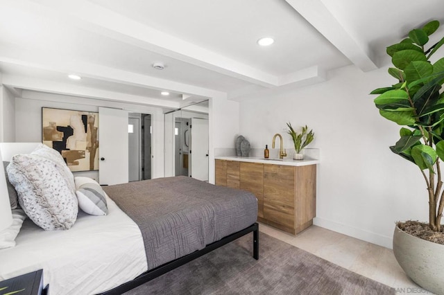 bedroom featuring beam ceiling and sink