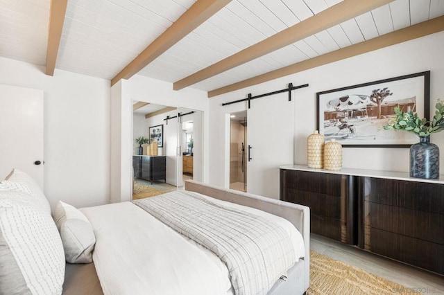 bedroom with beam ceiling and a barn door