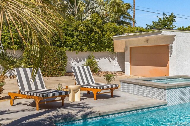 view of swimming pool with an in ground hot tub