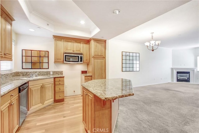 kitchen with pendant lighting, a center island, stainless steel appliances, sink, and a raised ceiling