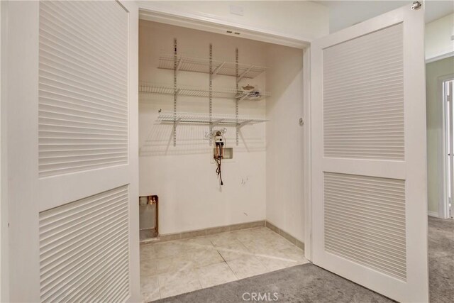 laundry room with tile patterned flooring, laundry area, and baseboards