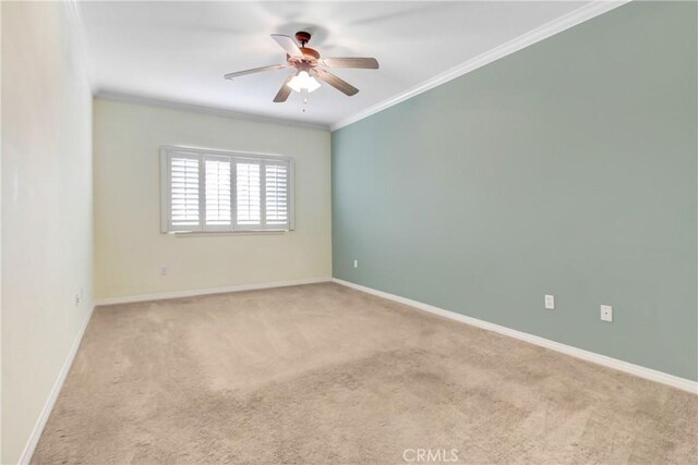 unfurnished room with ceiling fan, light colored carpet, and ornamental molding