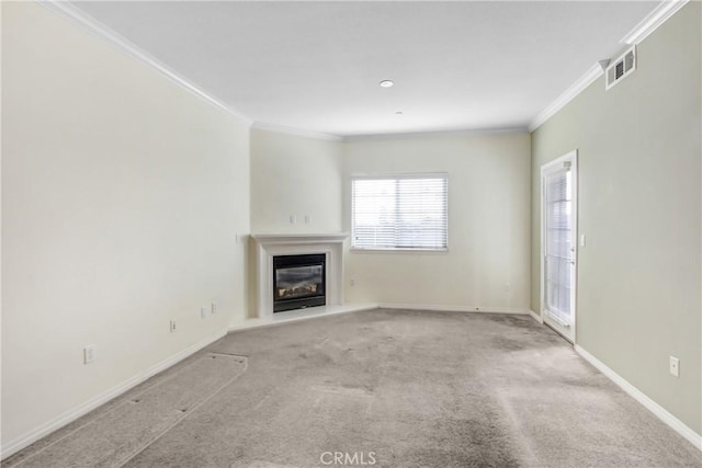 unfurnished living room featuring baseboards, visible vents, a glass covered fireplace, crown molding, and carpet flooring