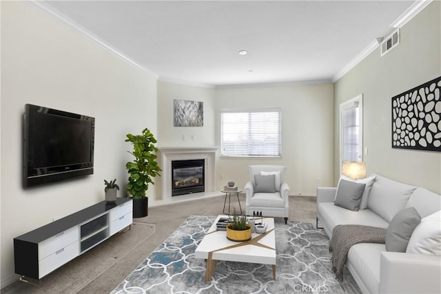 living area featuring visible vents, carpet flooring, a glass covered fireplace, and ornamental molding