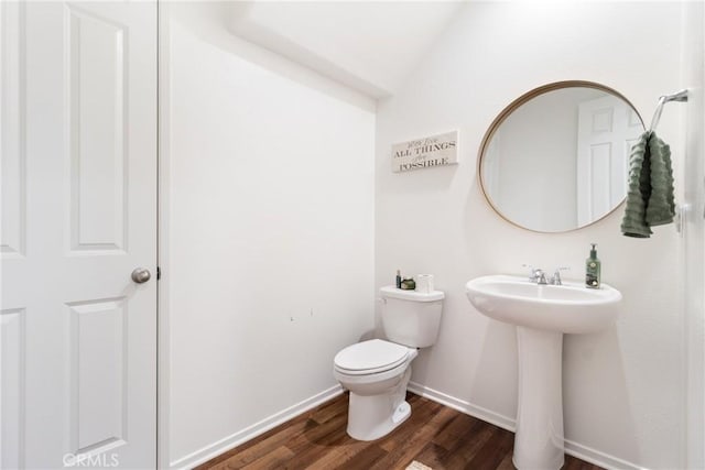 bathroom featuring sink, wood-type flooring, toilet, and vaulted ceiling