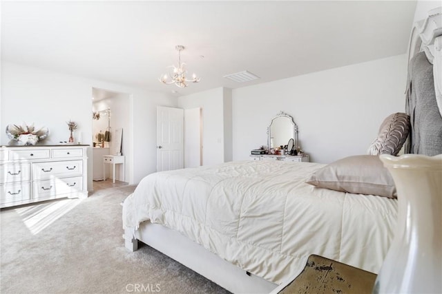 carpeted bedroom with connected bathroom and an inviting chandelier