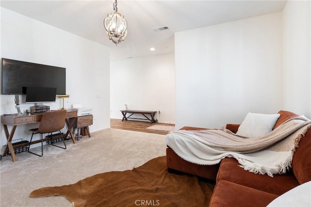 carpeted home office featuring a notable chandelier