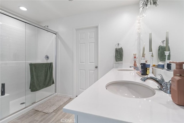 bathroom with a shower with shower door, wood-type flooring, and vanity