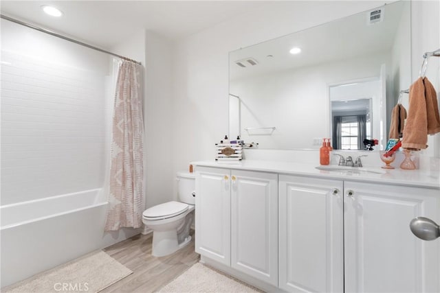 full bathroom featuring toilet, shower / bathtub combination with curtain, hardwood / wood-style flooring, and vanity