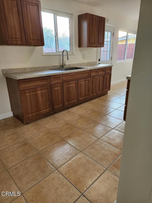 kitchen featuring light tile patterned floors and sink