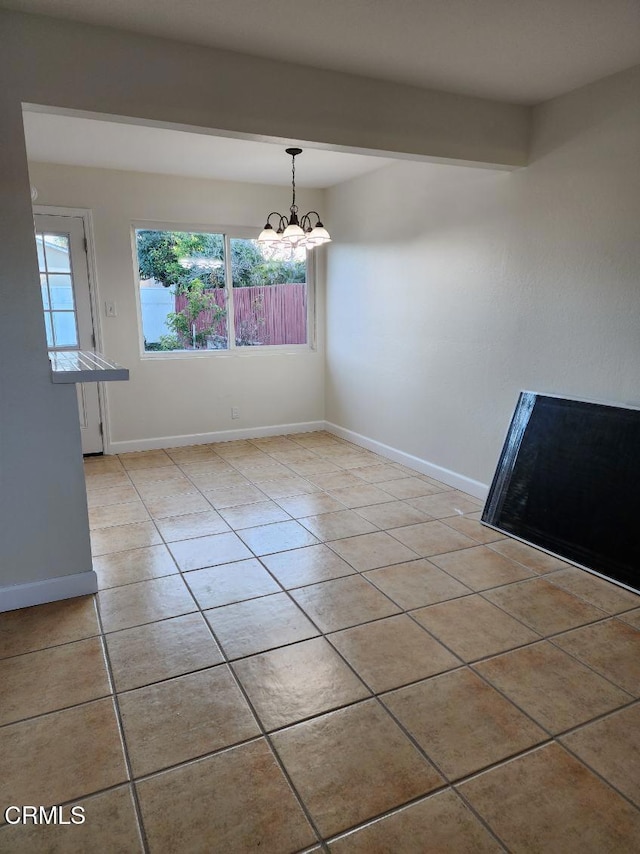 unfurnished dining area featuring an inviting chandelier and light tile patterned flooring