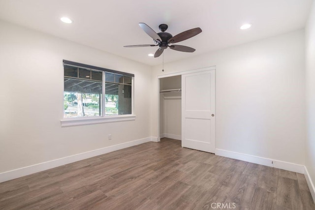 unfurnished bedroom with ceiling fan, wood-type flooring, and a closet