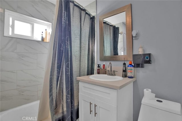 full bathroom featuring toilet, shower / bath combination with curtain, and vanity