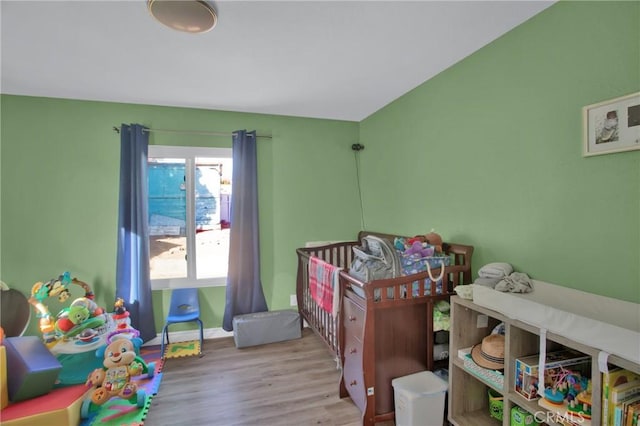 bedroom featuring light hardwood / wood-style flooring and a crib