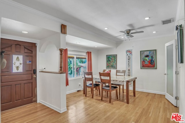 dining area with light wood-type flooring, ceiling fan, and ornamental molding