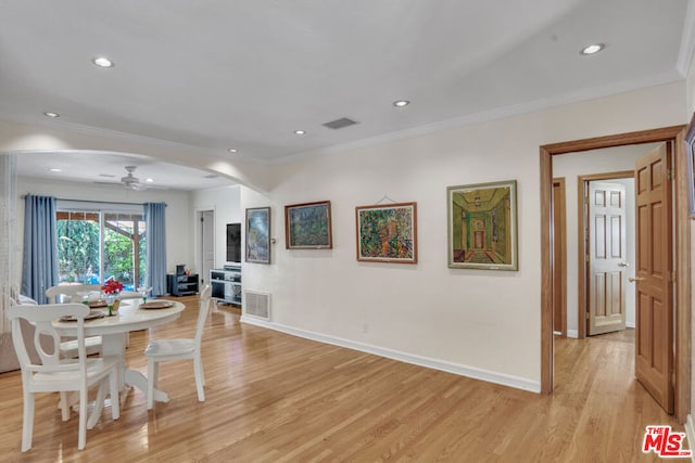 dining space with ceiling fan, light wood-type flooring, and ornamental molding