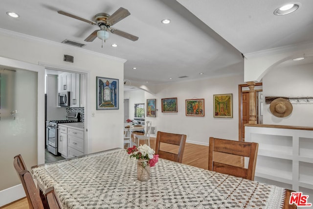 dining space featuring light wood-type flooring, ceiling fan, and crown molding