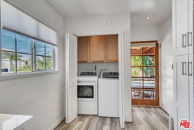 washroom featuring cabinets, washer and dryer, and light hardwood / wood-style floors