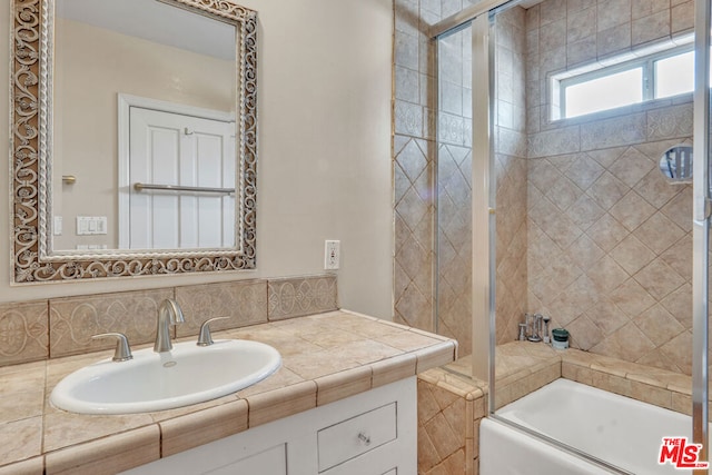 bathroom with enclosed tub / shower combo, backsplash, and vanity