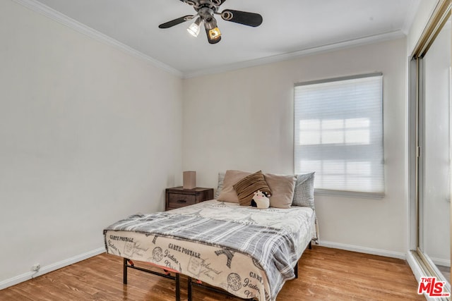 bedroom featuring ceiling fan, multiple windows, and light hardwood / wood-style flooring