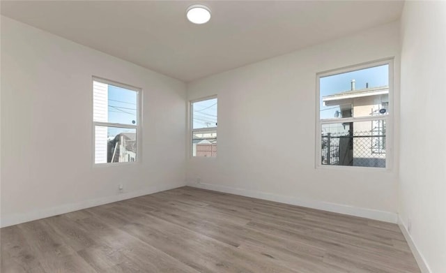 empty room featuring light wood-style floors and baseboards