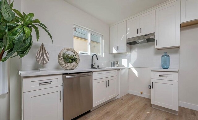 kitchen with white cabinetry, tasteful backsplash, dishwasher, light hardwood / wood-style flooring, and sink