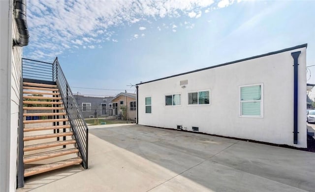 view of home's exterior featuring a patio, stairway, and stucco siding