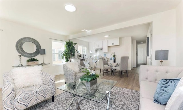 living area with light wood-style flooring and baseboards