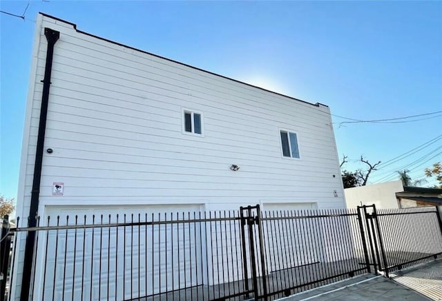 view of property exterior featuring a fenced front yard and a garage