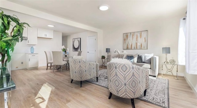 living area featuring light wood-style floors and baseboards