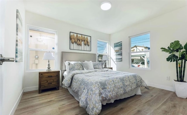 bedroom with baseboards and wood finished floors