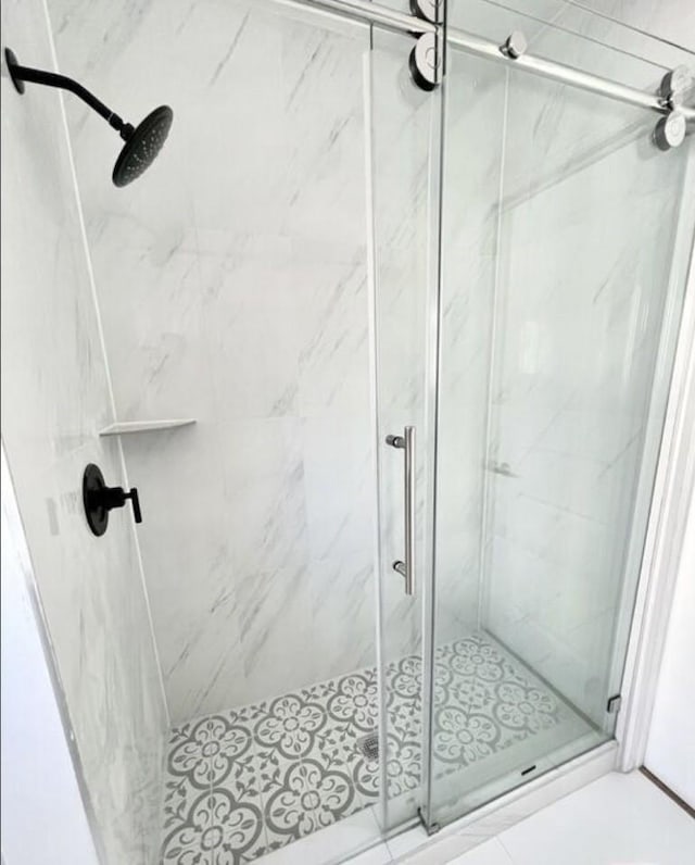 bathroom featuring a marble finish shower