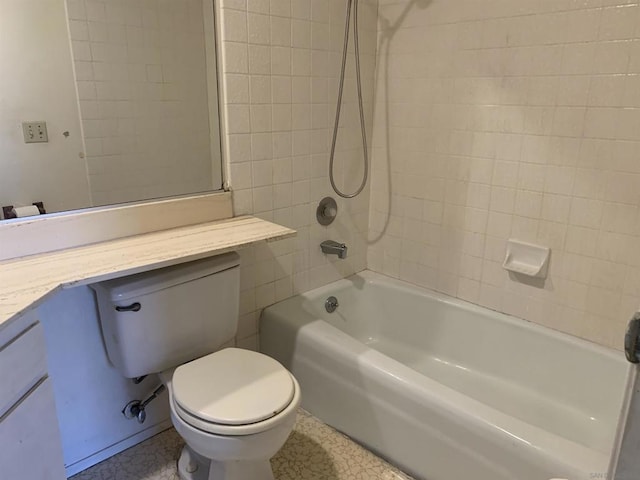 full bathroom featuring tiled shower / bath combo, vanity, and toilet