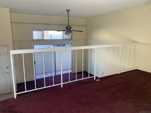 empty room featuring ceiling fan and carpet