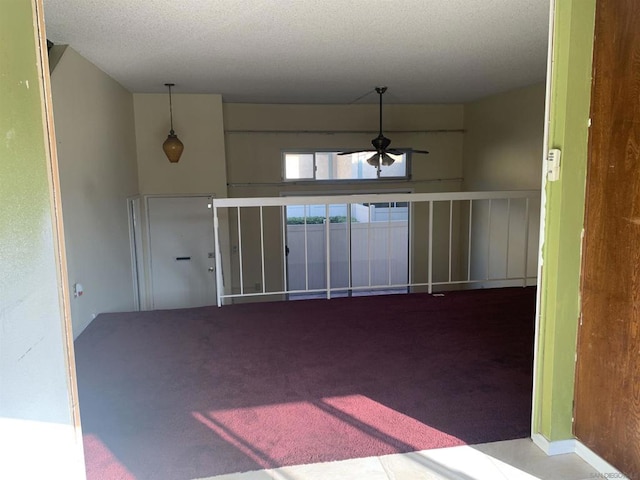 spare room featuring ceiling fan, a textured ceiling, and carpet floors